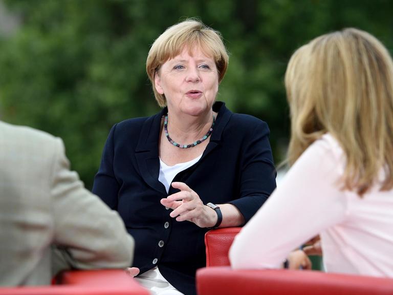 Bundeskanzlerin Angela Merkel (M, CDU) wird am 28.08.2016 auf einer Empore des Elisabeth-Lüders-Hauses in Berlin von den ARD-Moderatoren Tina Hassel und Thomas Baumann befragt.