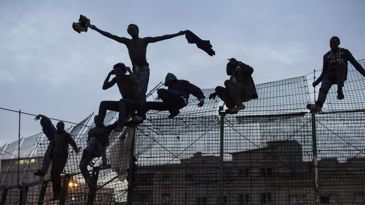 Flüchtlinge am Grenzzaun in der spanischen Exklave Melilla in Nordafrika, an der Grenze zu Marokko.