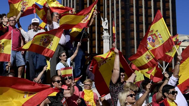 Menschen schwenken spanische Flaggen in Madrid
