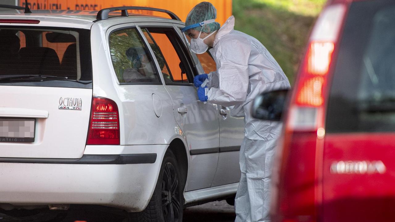 Ein Sanitäter des tschechischen Universitätsklinikums Hradec Kralove führt einen Corona-Test bei einer Person im Auto durch. Ein Sanitäter des tschechischen Universitätsklinikums Hradec Kralove führt einen Corona-Test bei einer Person im Auto durch.