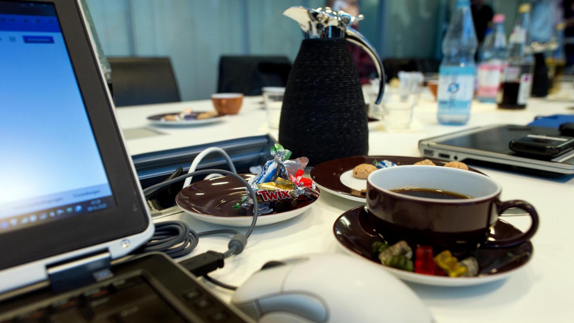 Süßigkeiten, Kaffee und Kekse stehen am 17.01.2015 während eines Meetings in einem Büro in Berlin neben einem Laptop. Foto: Arno Burgi | Verwendung weltweit Süßigkeiten, Kaffee und Kekse stehen am 17.01.2015 während eines Meetings in einem Büro in Berlin neben einem Laptop. Foto: Arno Burgi | Verwendung weltweit