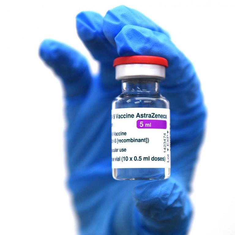 Eine Hand in blauem Schutzhandschuh hält ein Glasfläschchen mit dem Impfstoff von AstraZeneca im Lager des Universitätsklinikum in Tuebingen hohc. 