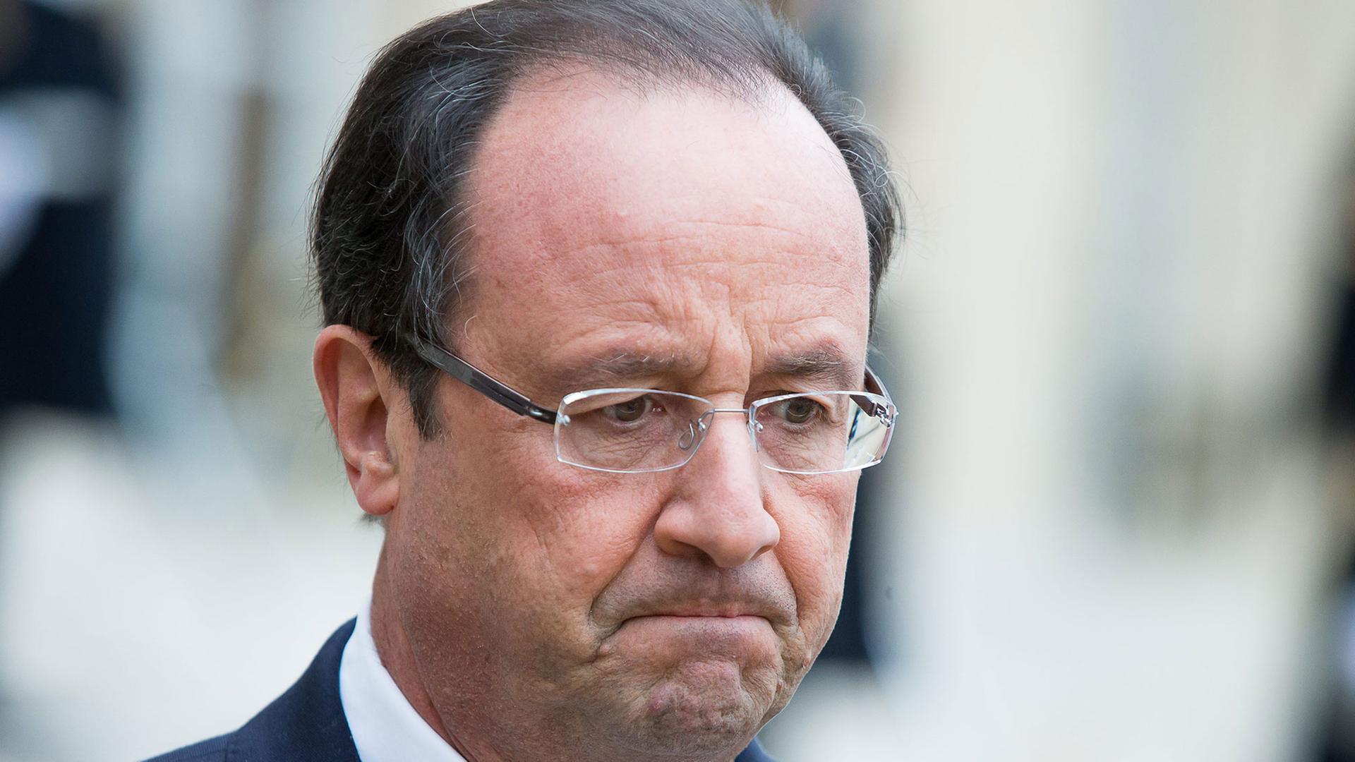 Porträtaufnahme von Frankreichs Staatspräsident François Hollande mit verkniffenem Gesichtsausdruck Porträtaufnahme von Frankreichs Staatspräsident François Hollande mit verkniffenem Gesichtsausdruck