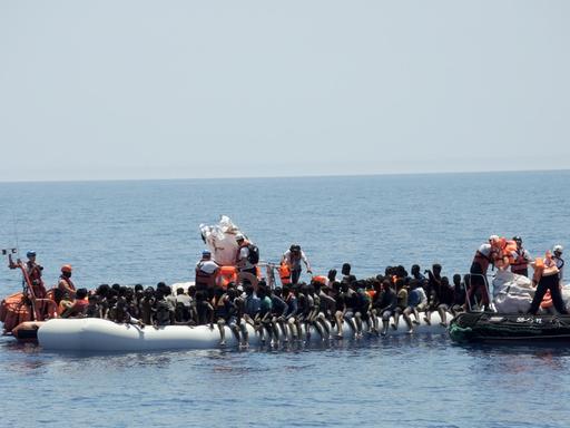 Rettungskräfte der Hilfsorganisationen Ärzte ohne Grenzen und SOS Méditerranée nähern sich einem überfüllten Schlauchboot im Mittelmeer. Die Menschen wurden auf das Rettungsschiff "Aquarius" gebracht.