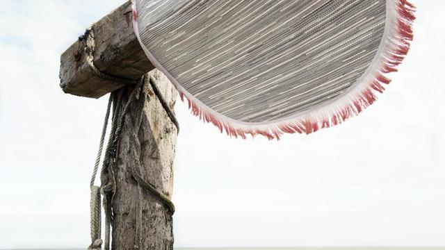 Der Teppich von Sep Verboom besteht aus Plastikseilen aus dem Meer - hier hängt er an einem Pfahl am Strand