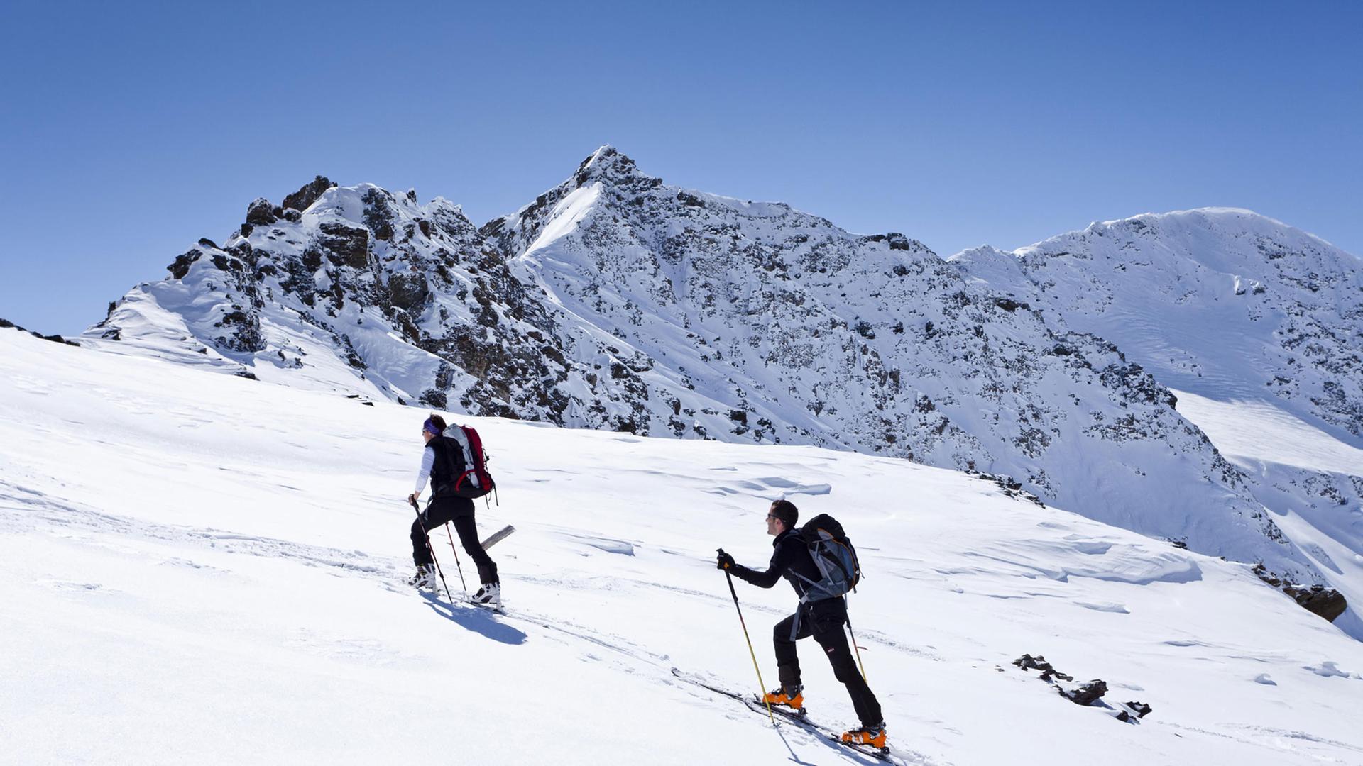 Zwei Männer mit Schiern auf einer Bergtour im Schnee Zwei Männer mit Schiern auf einer Bergtour im Schnee
