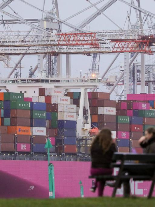 Im Containerhafen von Southampton: Zwei Frauen auf einer Bank, im Hintergrund eine Wand aus Containern