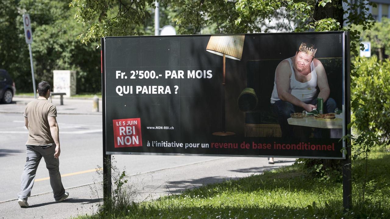 Ein Mann geht am 25.05.2016 in Genf an einem Plakat vorbei, das auf die bevorstehende Volksabstimmung in der Schweiz, im besonderen auf die Forderung nach bedingungslosem Grundeinkommen, aufmerksam macht. Ein Mann geht am 25.05.2016 in Genf an einem Plakat vorbei, das auf die bevorstehende Volksabstimmung in der Schweiz, im besonderen auf die Forderung nach bedingungslosem Grundeinkommen, aufmerksam macht.