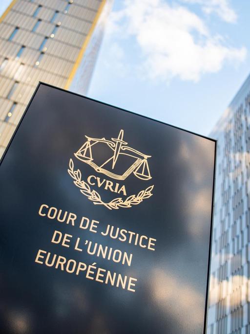 Das Bild zeigt ein Schild vor den Bürotürmen des Europäischen Gerichtshofs mit der Aufschrift "Cour de Justice de l'union Européene" im Europaviertel auf dem Kirchberg.