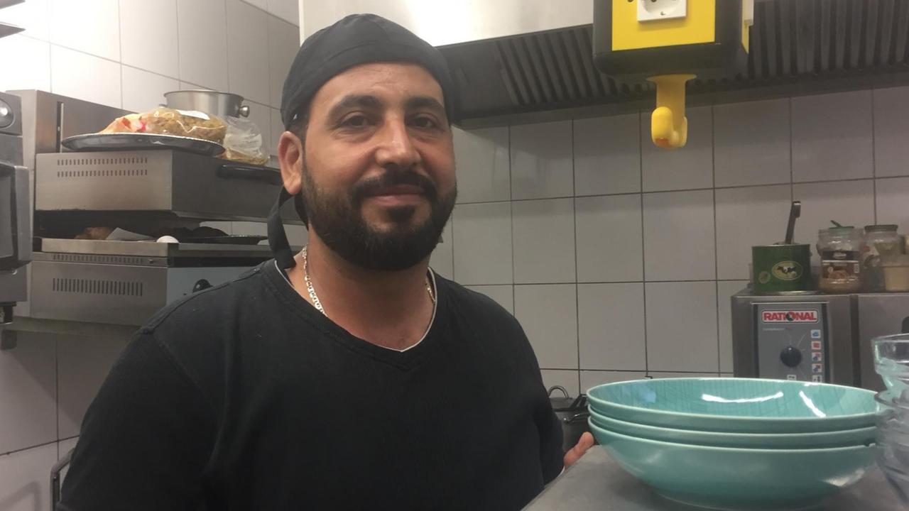 Der Koch Nur al Deen steht in der Küche eines Berliner Restaurants