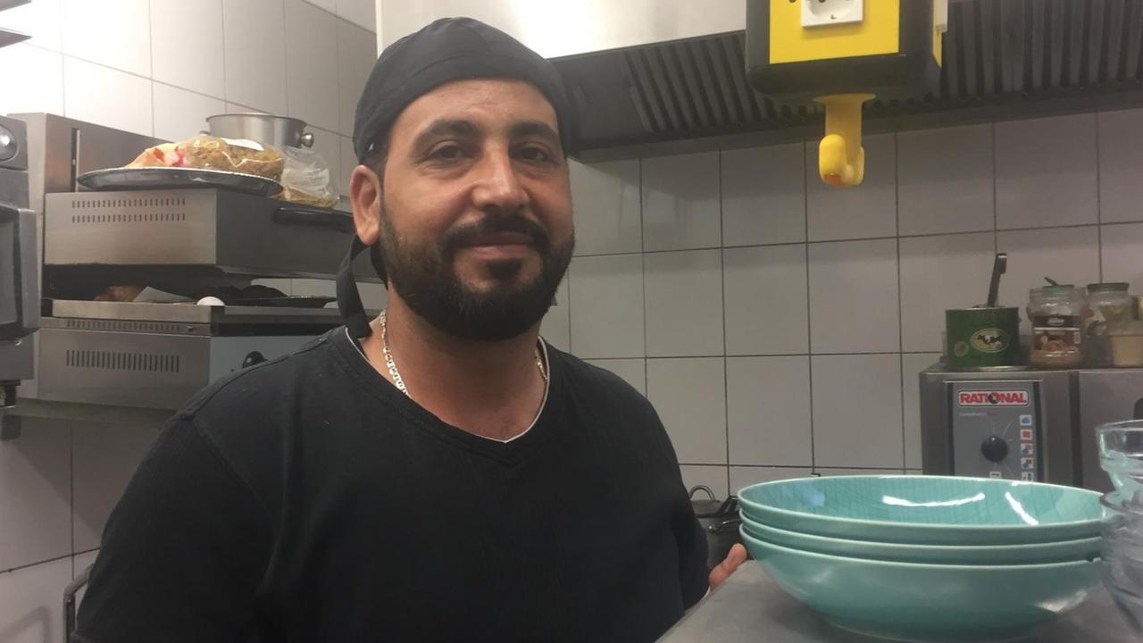 Der Koch Nur al Deen steht in der Küche eines Berliner Restaurants Der Koch Nur al Deen steht in der Küche eines Berliner Restaurants