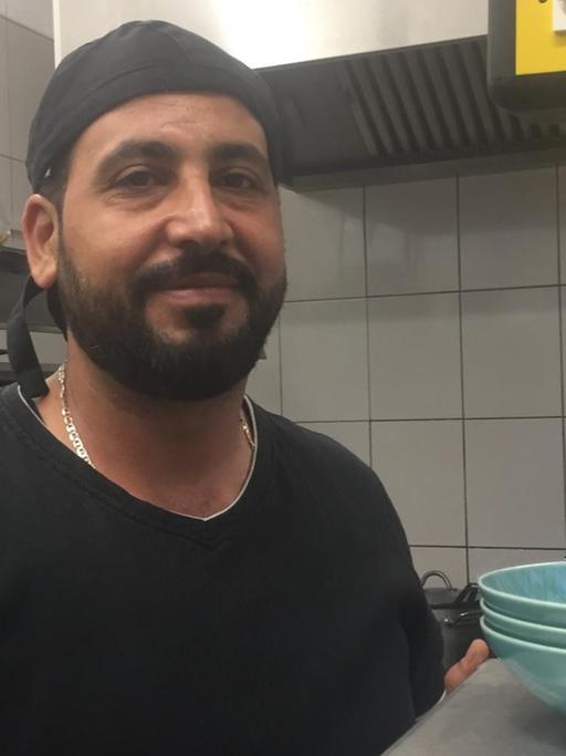 Der Koch Nur al Deen steht in der Küche eines Berliner Restaurants