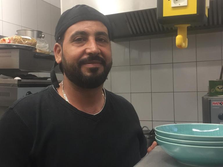 Der Koch Nur al Deen steht in der Küche eines Berliner Restaurants