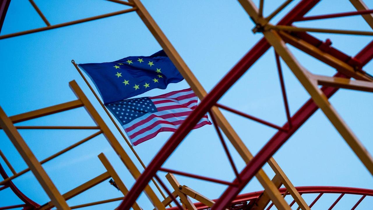 Eine EU-Fahne und eine US-Fahne wehen in Hamburg auf einer noch nicht fertig aufgebauten Achterbahn. Eine EU-Fahne und eine US-Fahne wehen in Hamburg auf einer noch nicht fertig aufgebauten Achterbahn.
