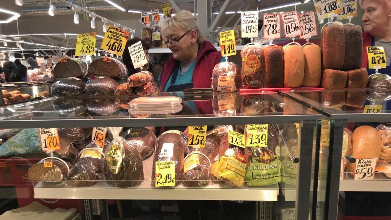 Eine Frau steht auf dem Wochenmarkt in Riga und verkauft Fleisch- und Wurstwaren. Eine Frau steht auf dem Wochenmarkt in Riga und verkauft Fleisch- und Wurstwaren.