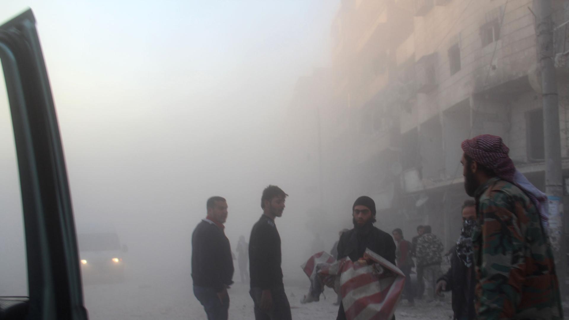 Ein Syrer rettet einen scheinbar leblosen Körper aus einem Haus nach einem Fassbomben-Angriff durch die syrische Armee in Aleppo. Ein Syrer rettet einen scheinbar leblosen Körper aus einem Haus nach einem Fassbomben-Angriff durch die syrische Armee in Aleppo.