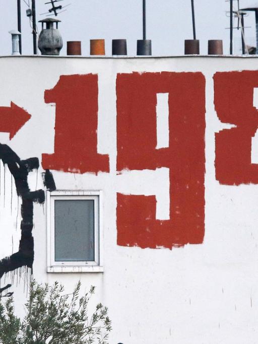 Ein Gebäude am Pariser Place de la Nation mit der Inschrift "1984". Es beziehet sich auf George Orwells Roman "1984" über einen totalitären Überwachungsstaat. Das Buch ist 1949 erschienen.