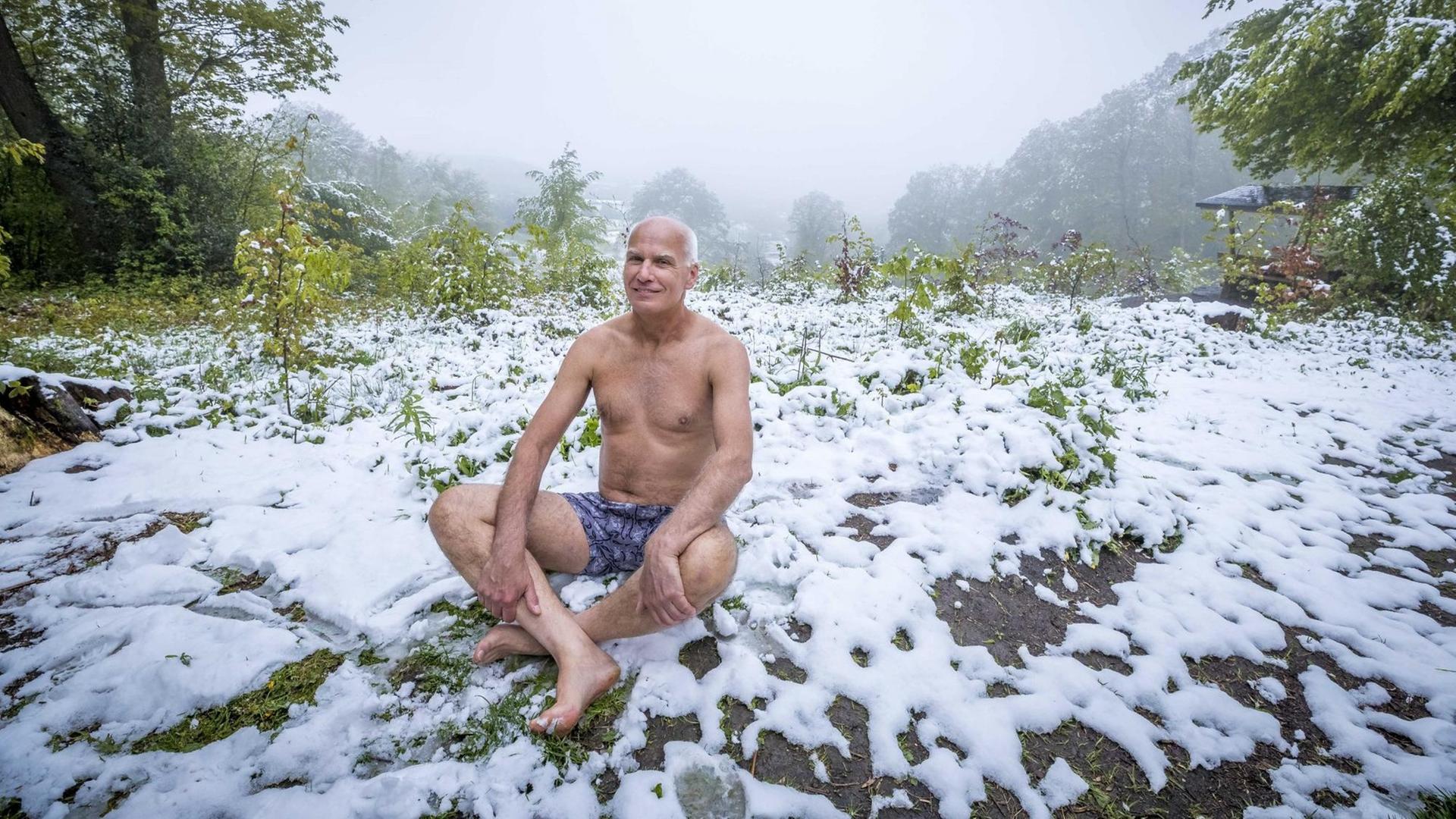 Ein Mann sitzt in Unterhose im frisch gefallenen Schnee. Ein Mann sitzt in Unterhose im frisch gefallenen Schnee.