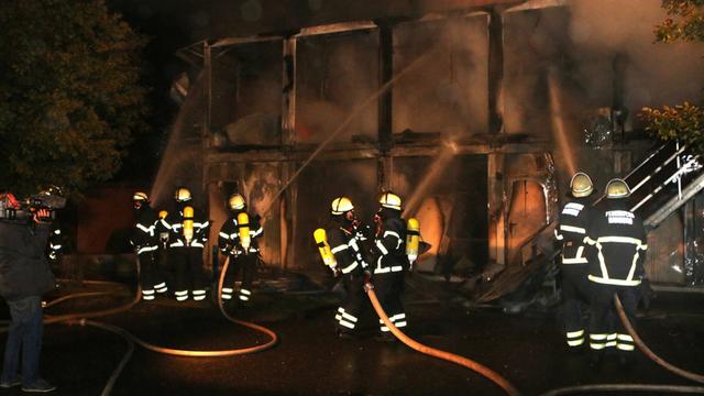 Die Feuerwehr löscht einen Brand in einem Flüchtlingslager im Stadtteil Sülldorf in Hamburg. 14 Container sind komplett ausgebrannt.