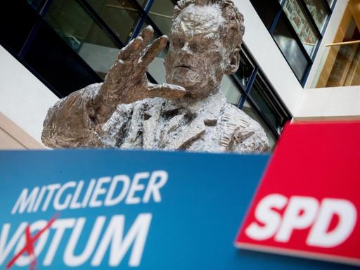 Rednerpult nach dem Mitgliedervotum der SPD für eine erneute Koalition mit den Unionsparteien, dahinter ein Standbild von Willy Brandt