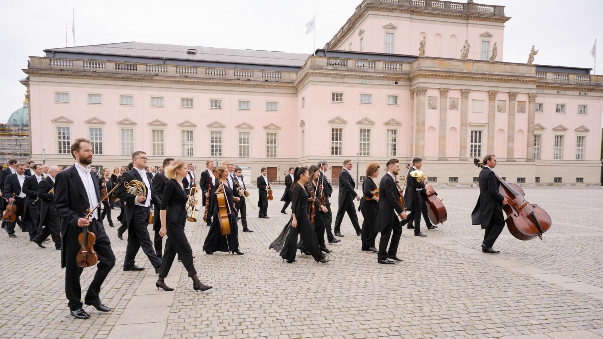 Musiker der Staatskapelle Berlin laufen vor dem Opernhaus mit ihren Instrumenten auf den Bebelplatz. Musiker der Staatskapelle Berlin laufen vor dem Opernhaus mit ihren Instrumenten auf den Bebelplatz.