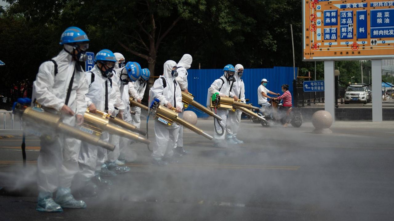 Maskiertes Personal desinfiziert ein Marktgelände in Peking, um den neuen Coronavirus-Ausbruch in der chinesischen Hauptstadt zu stoppen. Maskiertes Personal desinfiziert ein Marktgelände in Peking, um den neuen Coronavirus-Ausbruch in der chinesischen Hauptstadt zu stoppen.