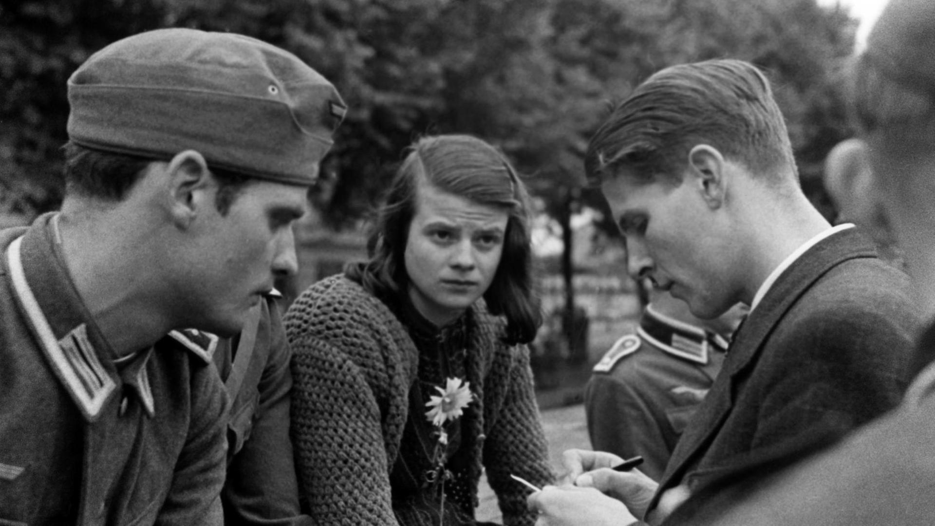Hans und Sophie Scholl sowie Christoph Probst. Aufnahme bei der Militärsammelstelle ihrer Münchner Studentenkompanie am Ostbahnhof München zur Abkommandierung an die Ostfront. Im Anschnitt Willi Graf.