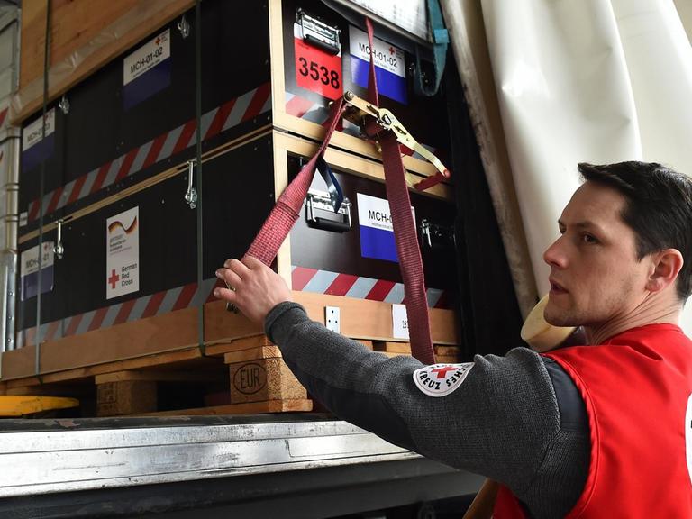 DRK-Mitarbeiter Manuel Frenzel sichert am 18.03.2016 in Schönefeld (Brandenburg) die Ladung eines LKW mit Hilfgütern. Das Deutsche Rote Kreuz (DRK) schickt eine Basisgesundheitsstation zur medizinischen Versorgung von rund 10.000 Menschen in die Region.