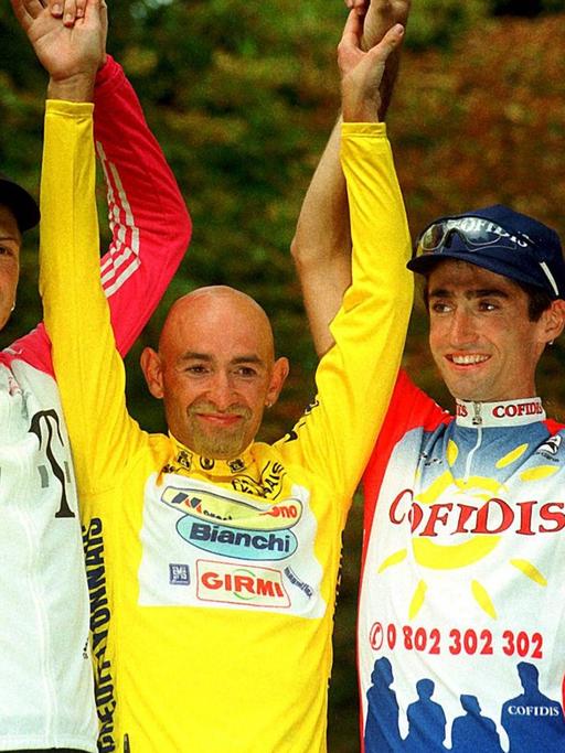 Zweitplazierter Jan Ullrich (Team Deutsche Telekom), Gesamtsieger Marco Pantani (Team Mercatone-Uno) und Drittplazierter Bobby Julich (Team Cofidis) reißen jubelnd die Arme hoch