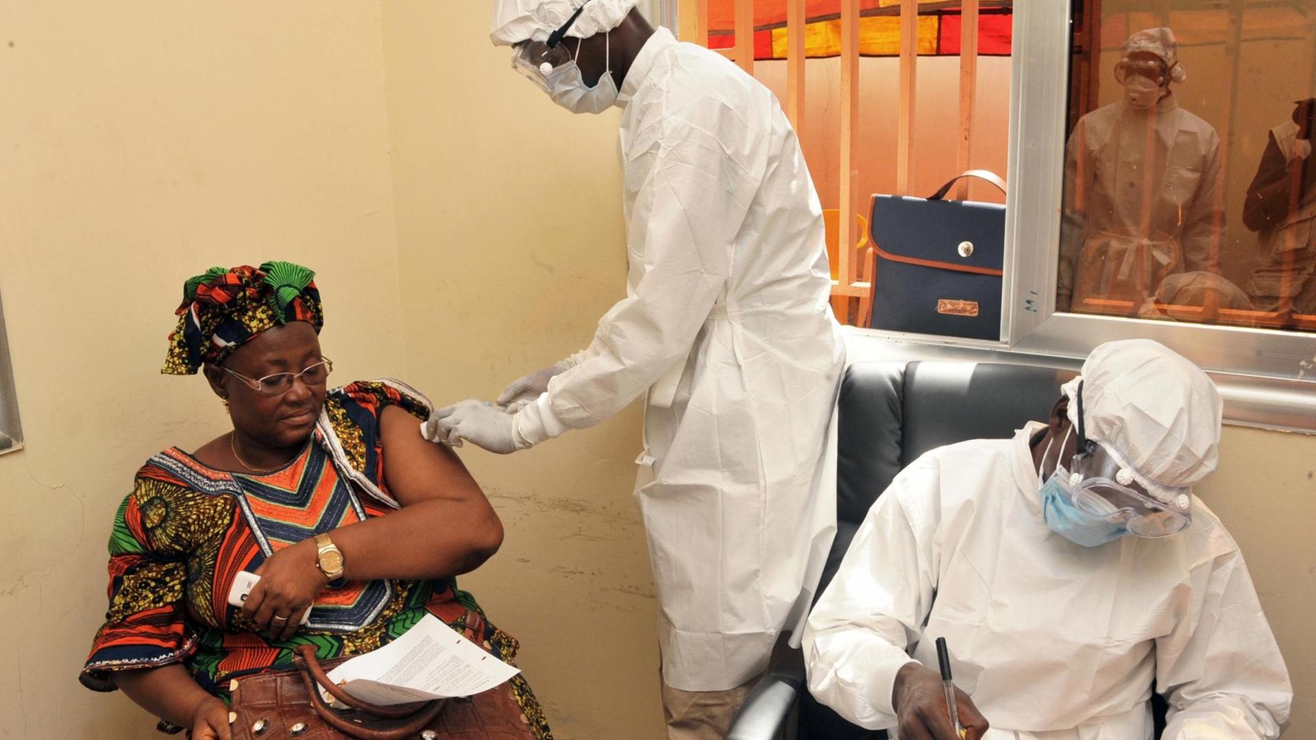 Eine Frau wird bei einem Feldversuch in Conakry gegen Ebola geimpft.