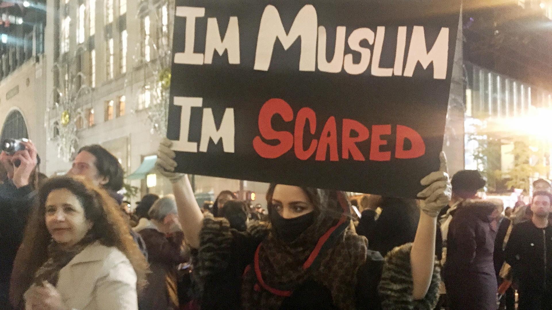 Eine junge Muslima hält in New York, USA, hält bei Protesten gegen die Wahl von Donald Trump zum neuen US-Präsidenten ein Schild mit der Aufschrift "Im Muslim I'm scared" – etwa: "Ich bin Muslima, ich füchte mich" – hoch. Eine junge Muslima hält in New York, USA, hält bei Protesten gegen die Wahl von Donald Trump zum neuen US-Präsidenten ein Schild mit der Aufschrift "Im Muslim I'm scared" – etwa: "Ich bin Muslima, ich füchte mich" – hoch.