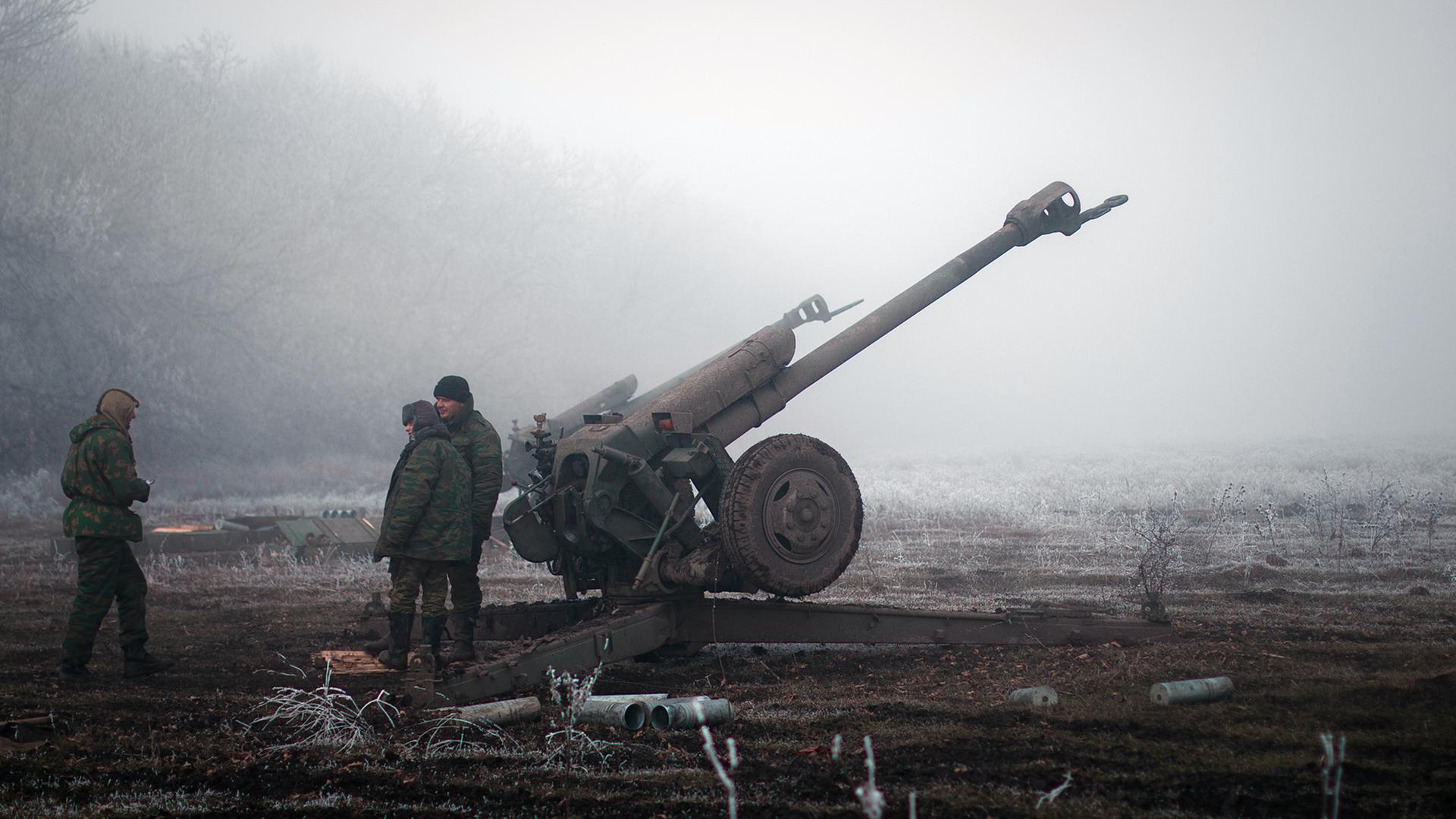 Separatisten im Osten der Ukraine stehen neben einer Artillerie-Kanone. Separatisten im Osten der Ukraine stehen neben einer Artillerie-Kanone.