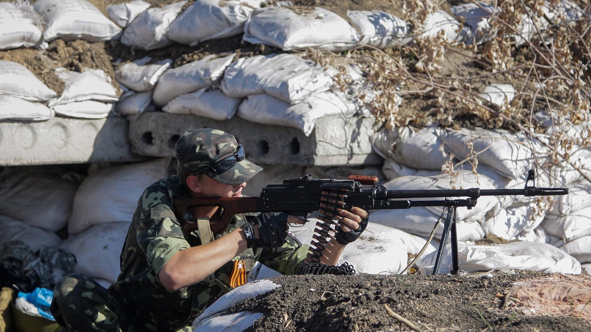 Pro-russische Rebellen gehen am 13.10.2014 bei einer Kontrollstelle nahe Donezk, Ukraine; in Position. Pro-russische Rebellen gehen am 13.10.2014 bei einer Kontrollstelle nahe Donezk, Ukraine; in Position.