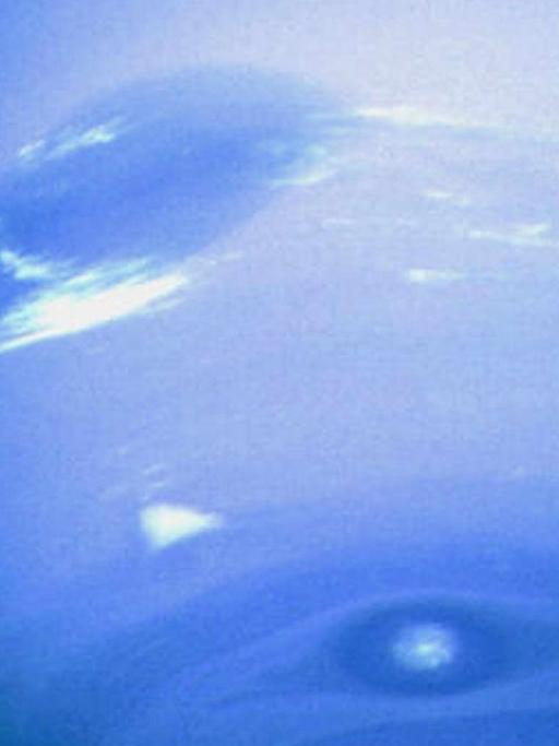 Das von der NASA-Raumsonde Voyager 2 am 21.8.2001 gemachte Foto zeigt den Planeten Neptun. Deutlich zu sehen sind in der Atmosphäre aus (farblosem) Wasserstoff und Helium sowie kleinen Mengen (blauem) Methan, die hellen Flecken.