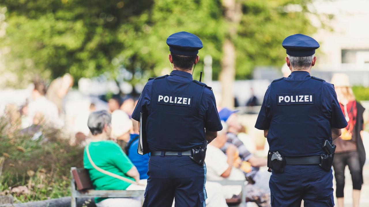 Rückenaufnahme von Polizisten im Park. Rückenaufnahme von Polizisten im Park.