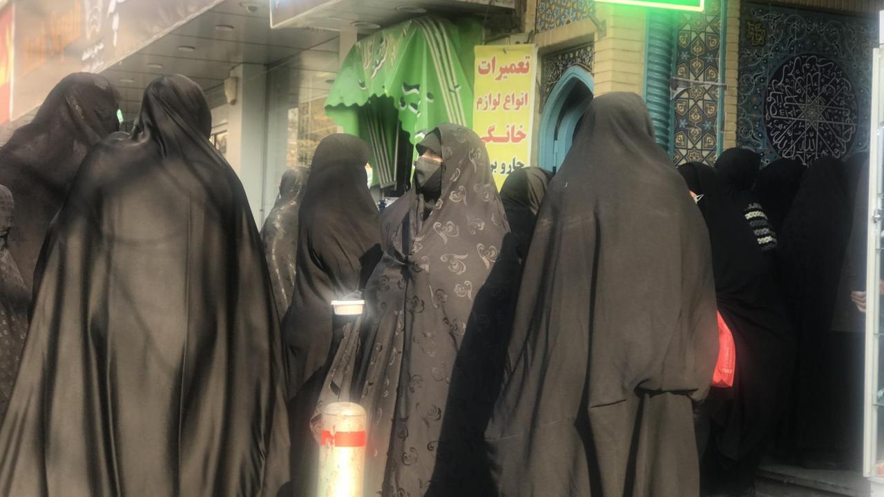 Vielen Frauen im Tschador drängen sich dicht aneinander am Eingang einer Moschee. Vielen Frauen im Tschador drängen sich dicht aneinander am Eingang einer Moschee.