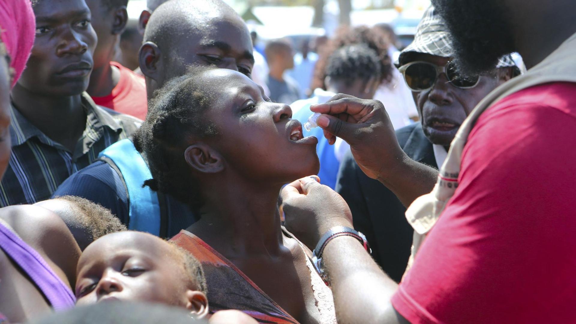 Mosambik, Beira: Eine Frau erhält eine orale Cholera-Impfung in einem Lager für Vertriebene des Zyklons «Idai».