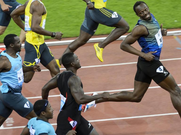 Der jamaikanische Sprinter Usain Bolt (r.) schaut sich nach seinen Mitläufern um.