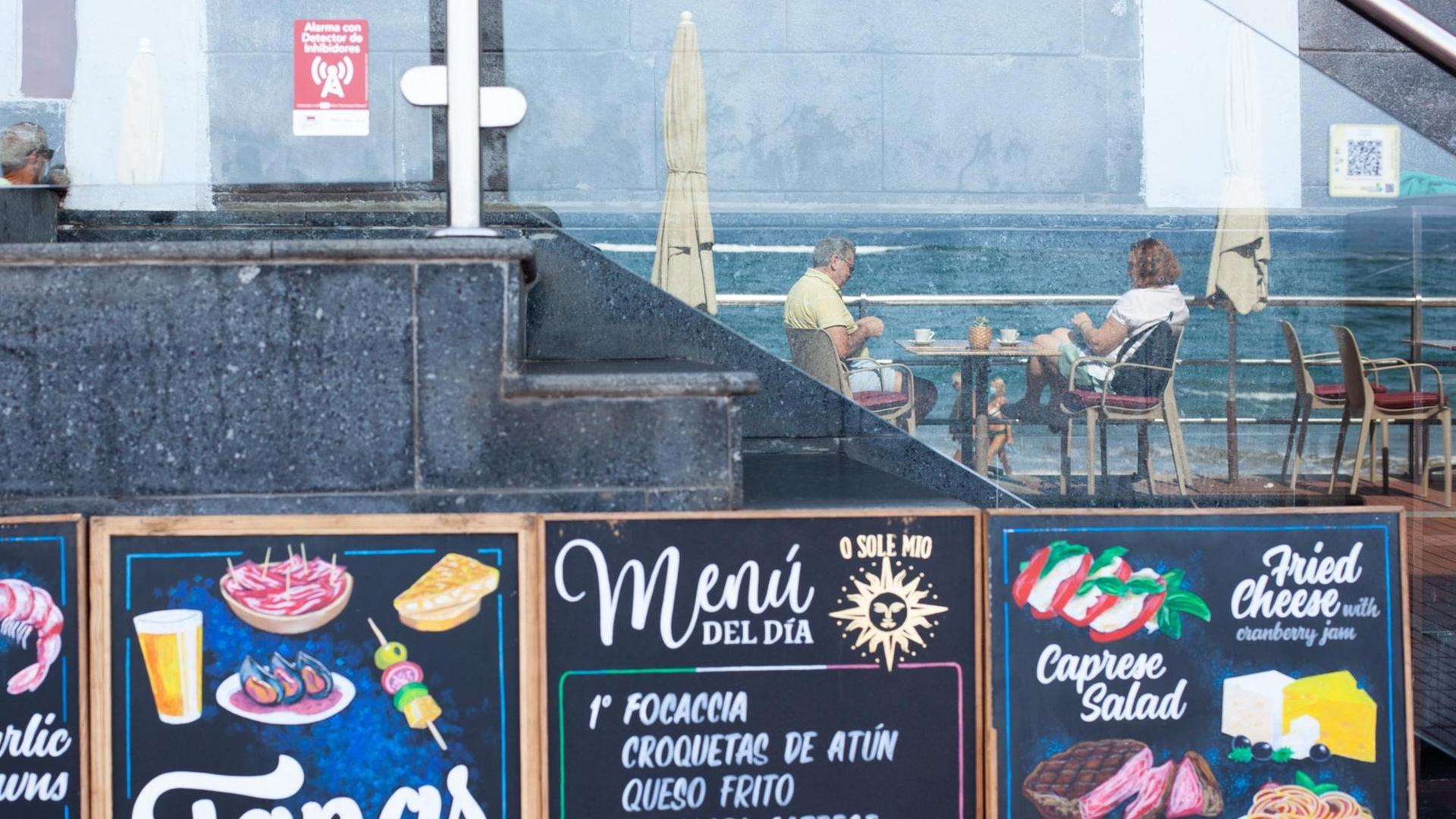 Kunden in einer Bar am Strand von Las Canteras in Gran Canaria spiegeln sich am 14.10.2020 in einem Glas. Kunden in einer Bar am Strand von Las Canteras in Gran Canaria spiegeln sich am 14.10.2020 in einem Glas.