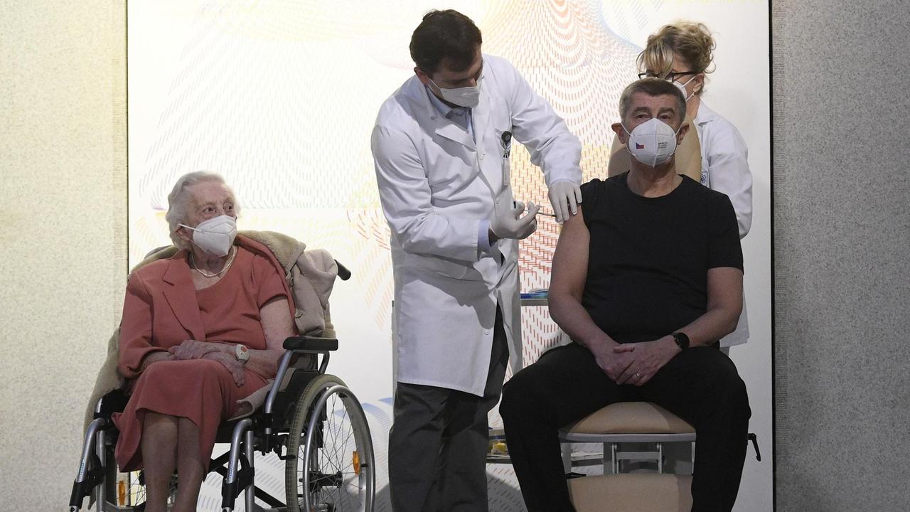 Emilie Repikova (links),Veteranin des Zweiten Weltkriegs, beobachtet wie Andrej Babis, Premierminister von Tschechien, im Zentralen Militärkrankenhaus mit dem Corona-Impfstoff geimpft wird. Emilie Repikova (links),Veteranin des Zweiten Weltkriegs, beobachtet wie Andrej Babis, Premierminister von Tschechien, im Zentralen Militärkrankenhaus mit dem Corona-Impfstoff geimpft wird.