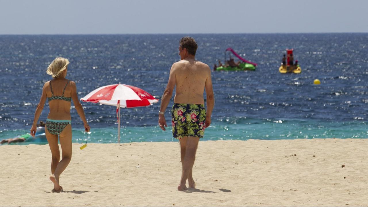 Touristen laufen am Strand auf Mallorca. Touristen laufen am Strand auf Mallorca.
