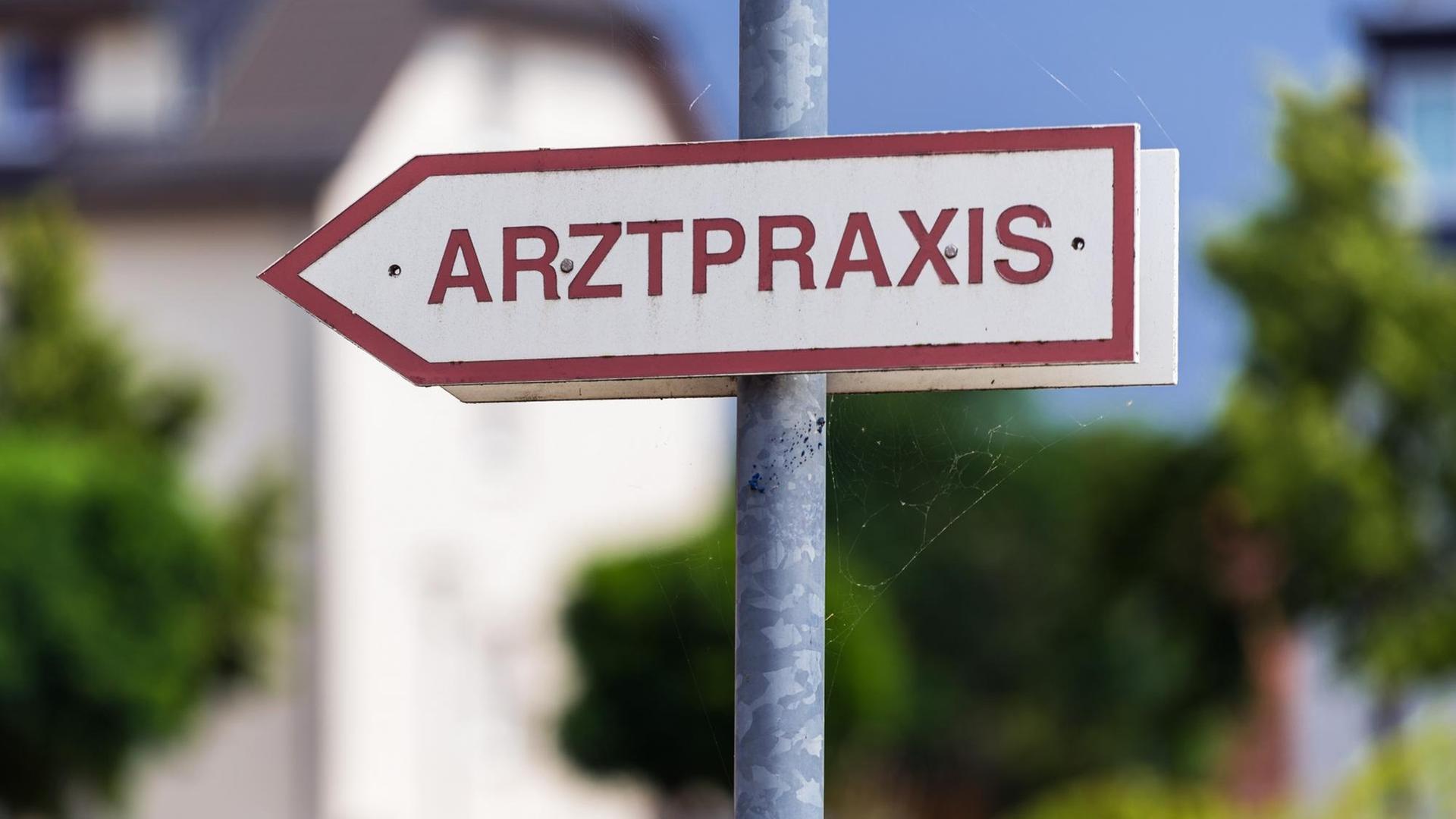 Ein Schild „Arztpraxis“ steht an der Straße. Ein Schild „Arztpraxis“ steht an der Straße.