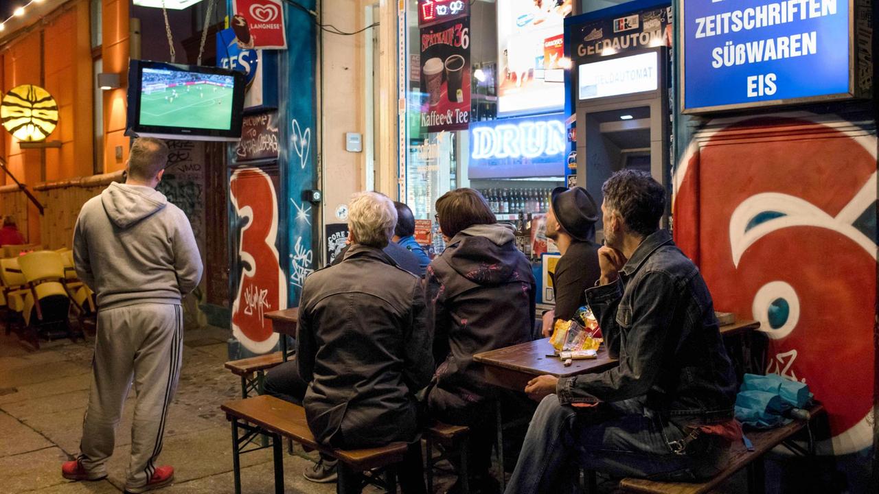 Fans schauen am 12.06.2016 beim Public Viewing vor einem Spätkauf in Berlin das Spiel der deutschen Mannschaft gegen die Ukraine bei der Fußball-EM in Frankreich auf einem Fernseher. Fans schauen am 12.06.2016 beim Public Viewing vor einem Spätkauf in Berlin das Spiel der deutschen Mannschaft gegen die Ukraine bei der Fußball-EM in Frankreich auf einem Fernseher.