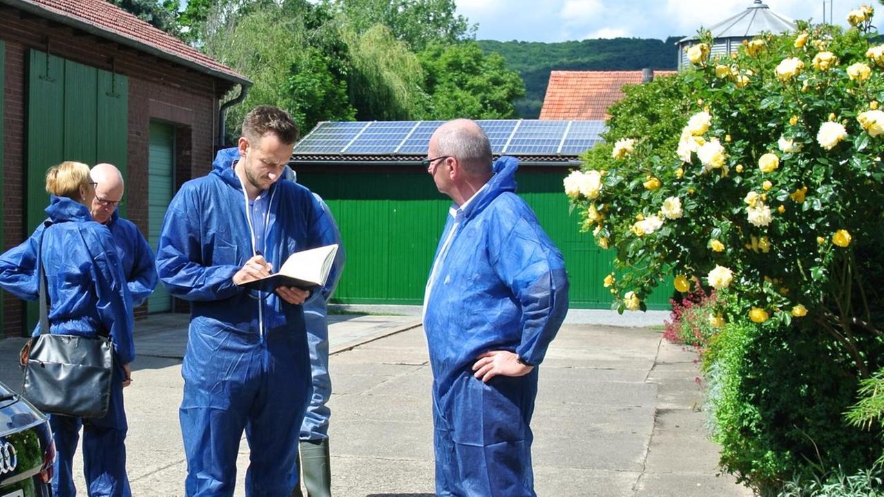 Benjamin Piel, Chefredakteur des Mindener Tageblatts, steht in einem blauen Schutzanzug vor einem Stall und macht sich Notizen. Benjamin Piel, Chefredakteur des Mindener Tageblatts, steht in einem blauen Schutzanzug vor einem Stall und macht sich Notizen.