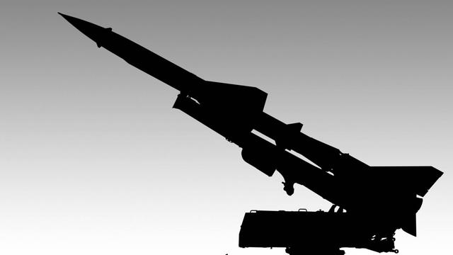 Ein Raketen- oder Geschosswerfer als schwarze Silhouette vor hellem Hintergrund.