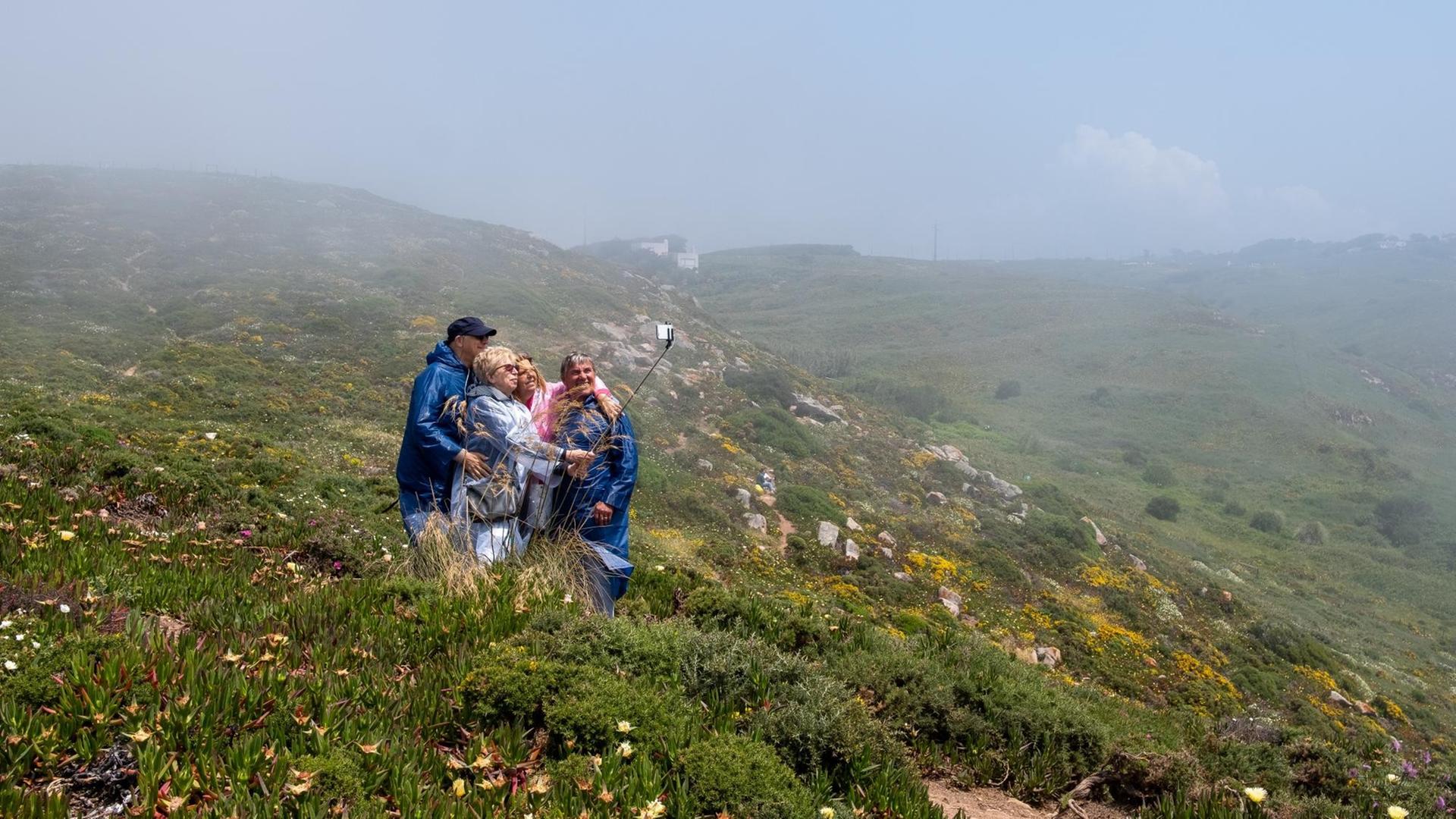 Eine Reisegruppe fotografiert sich in Portugal auf einer hügeligen grünen Wiese. Eine Reisegruppe fotografiert sich in Portugal auf einer hügeligen grünen Wiese.