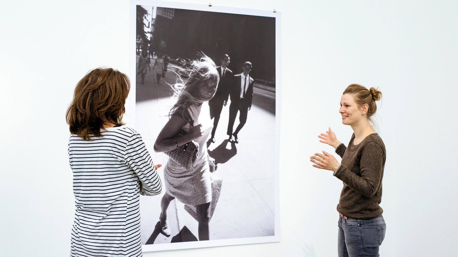 Zwei Ausstellungsbesucherinnen vor einer Schwarz-Weiß-Fotografie mit einer Frau in den Straßen New Yorks von Peter Lindbergh in "Women on Street" Zwei Ausstellungsbesucherinnen vor einer Schwarz-Weiß-Fotografie mit einer Frau in den Straßen New Yorks von Peter Lindbergh in "Women on Street"