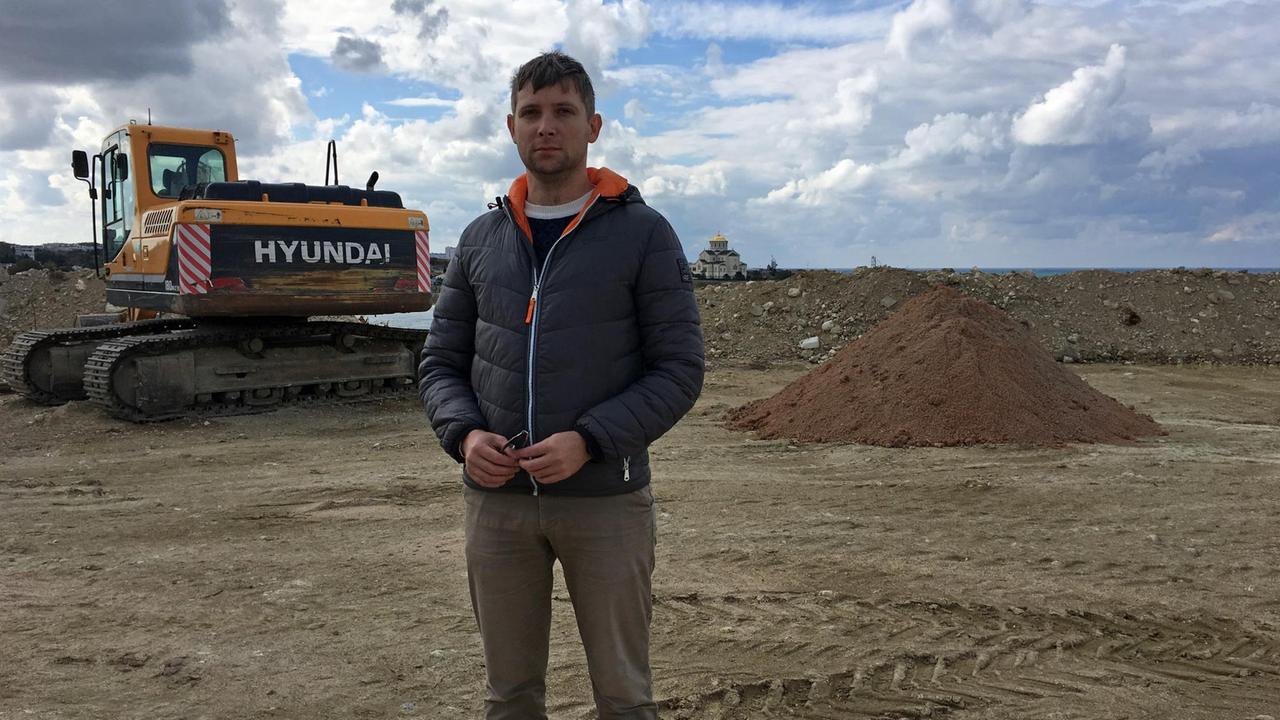Kläger gegen das Revolutions-Denkmal Kirill Sisikow steht auf dem Beton-Fundament. Kläger gegen das Revolutions-Denkmal Kirill Sisikow steht auf dem Beton-Fundament.