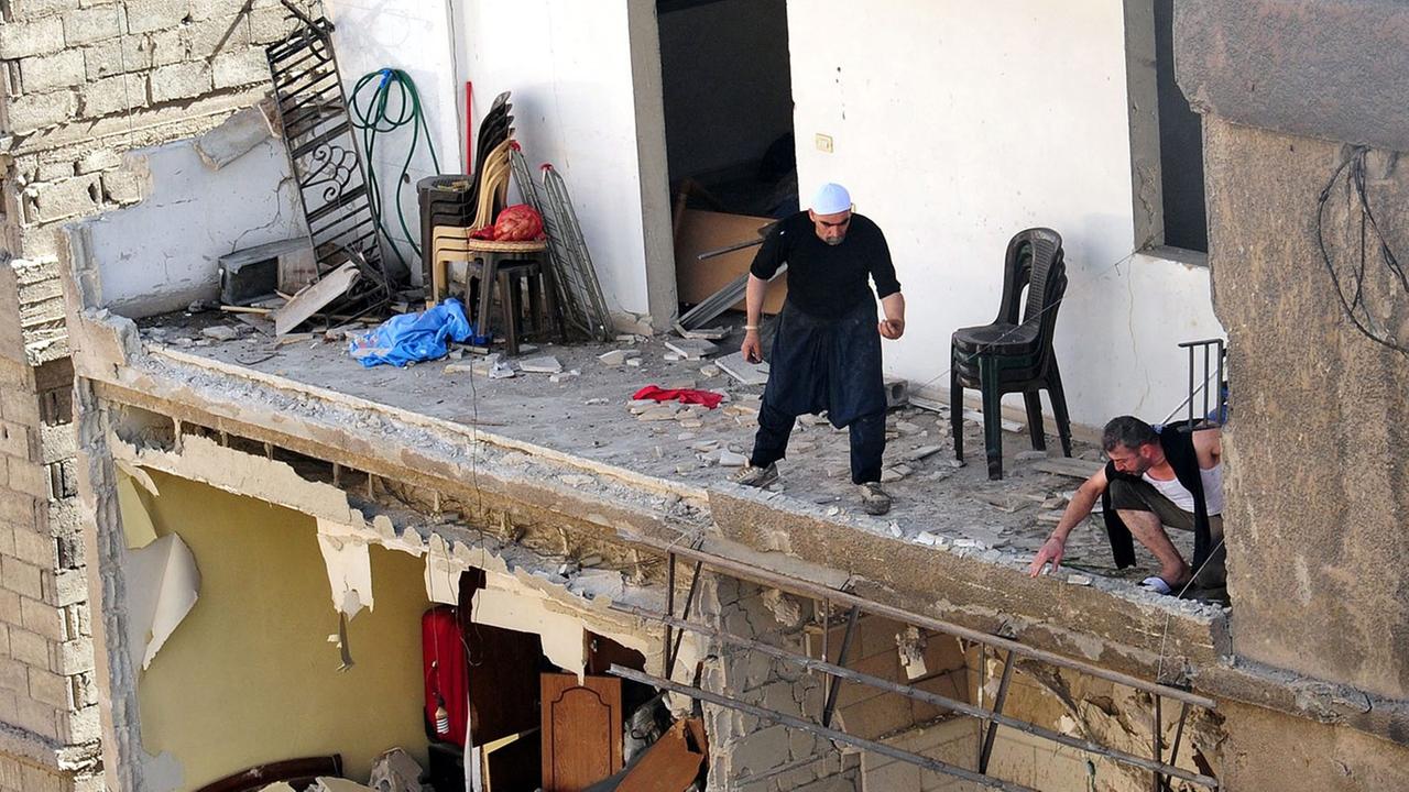 Menschen in einem zerstörten Gebäude nach einer Explosion in Damaskus Menschen in einem zerstörten Gebäude nach einer Explosion in Damaskus