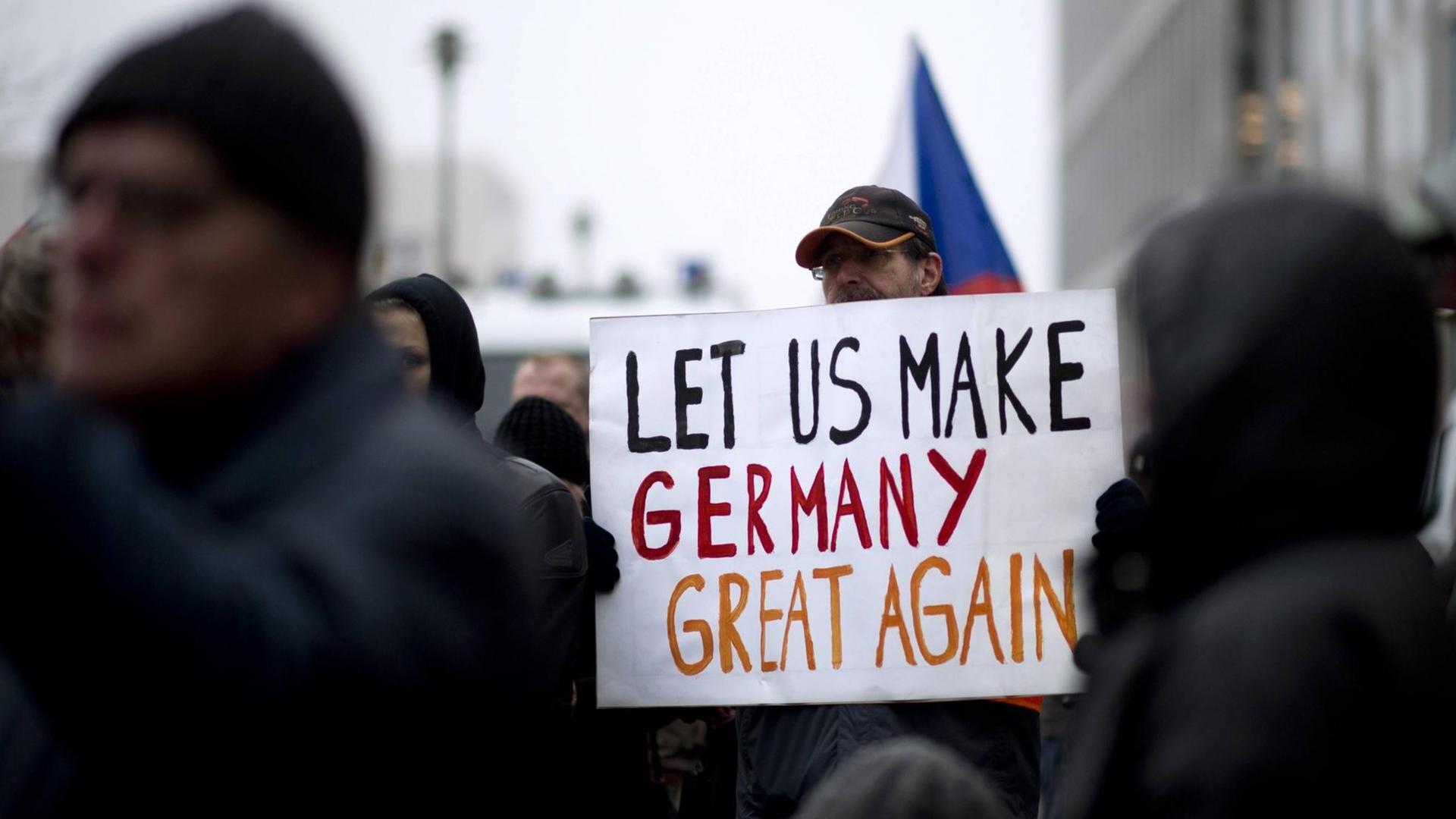 Ein Demonstrant der Bergida-Bewegung, einem Ableger von Pegida, hält ein Plakat mit der Aufschrift "Let us make Germany great again" am Hauptbahnhof im Regierungsviertel in Berlin. Ein Demonstrant der Bergida-Bewegung, einem Ableger von Pegida, hält ein Plakat mit der Aufschrift "Let us make Germany great again" am Hauptbahnhof im Regierungsviertel in Berlin.